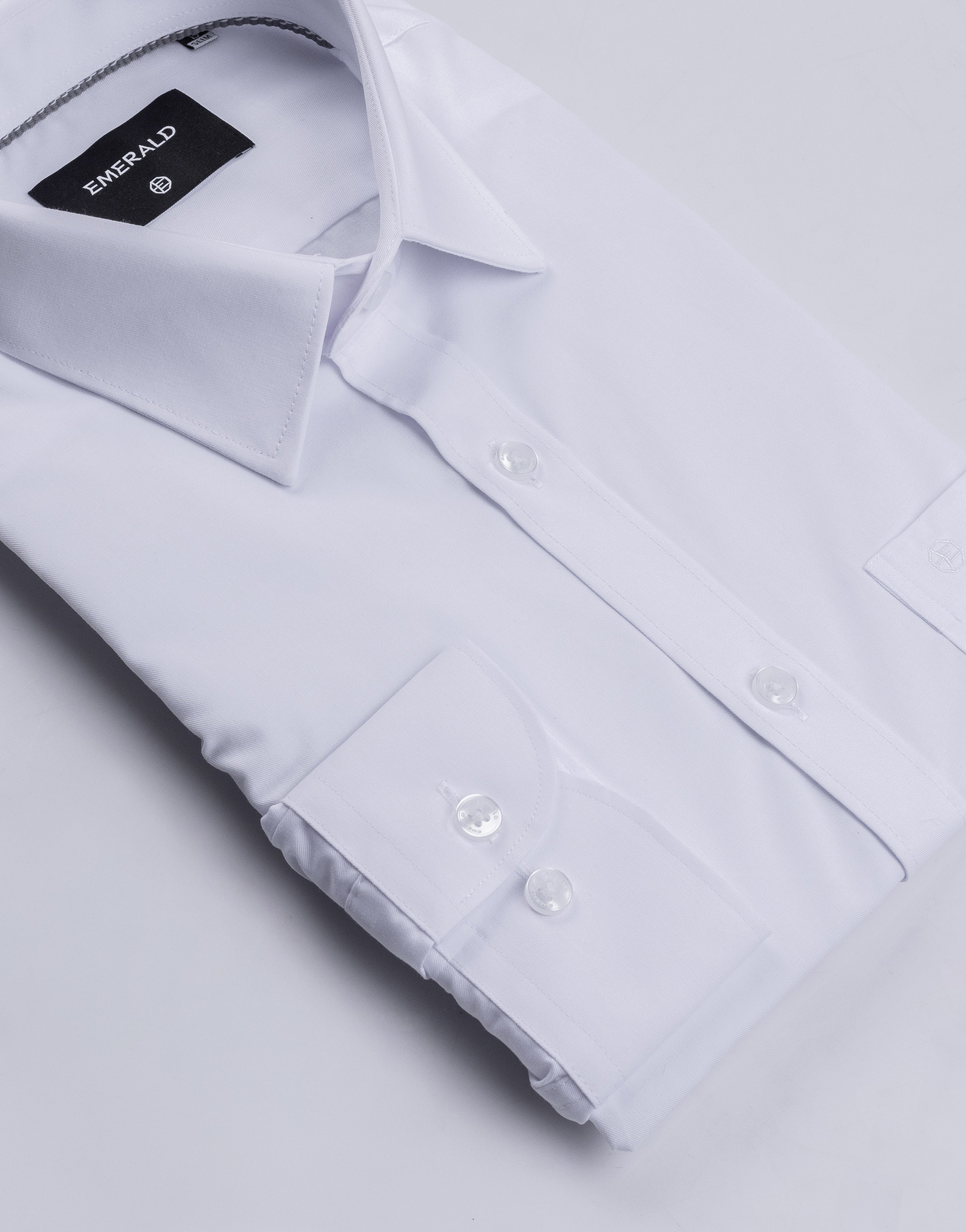 Close-up of a white dress shirt with a collar and buttons on a light gray background.